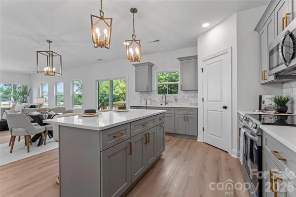 a kitchen with a sink stove cabinets and wooden floor
