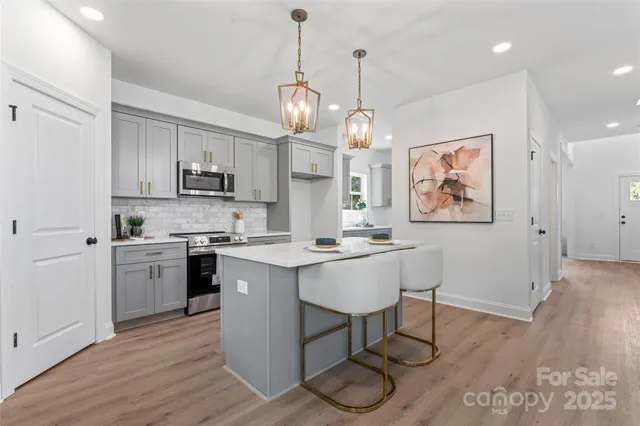 a kitchen that has a lot of cabinets and wooden floor