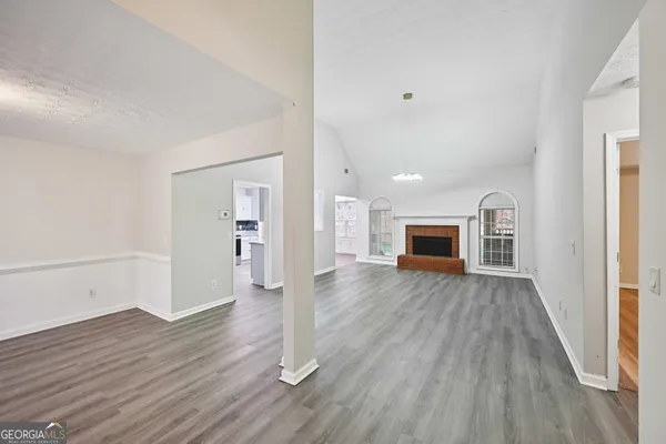 a view of a hallway with wooden floor and a bathroom