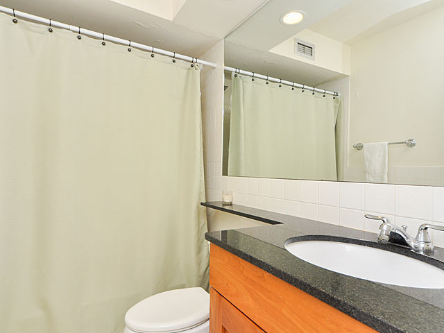 3033 North Sheridan Road, Unit 708 Chicago, IL 60657 - Photo 8 of 8 a bathroom with a granite countertop sink mirror vanity and toilet