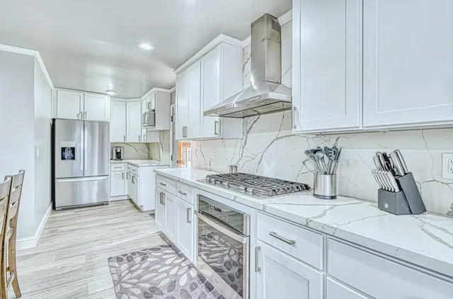 a kitchen with stainless steel appliances kitchen island granite countertop a sink and cabinets