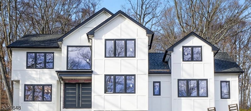 a front view of a house with glass windows and stairs