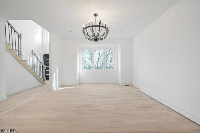 a view of empty room with wooden floor and windows