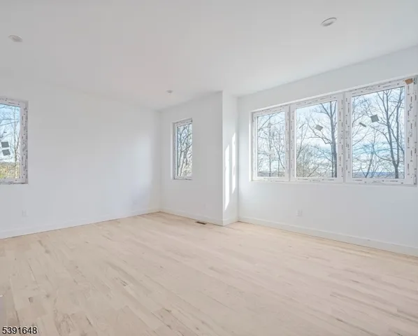 an empty room with windows and fireplace