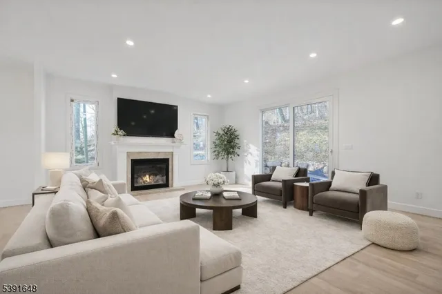 a living room with furniture a fireplace and a large window