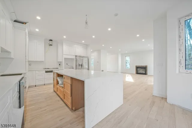 a large kitchen with stainless steel appliances kitchen island a large counter top and a wooden floors