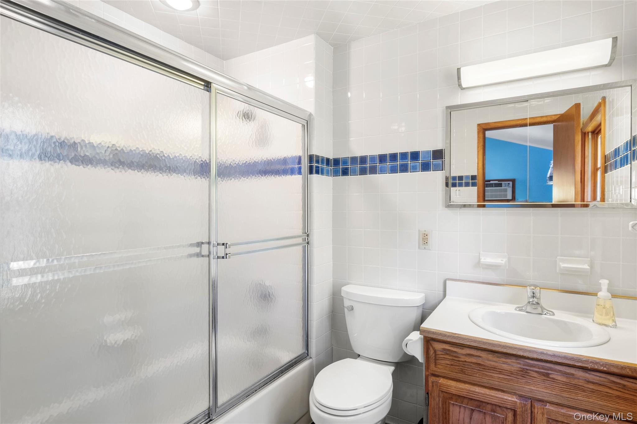 250 Paradise Point Road Southold, NY 11971 - Photo 15 of 24 a bathroom with a sink a mirror and a toilet