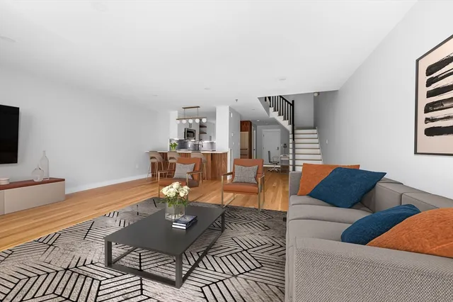 a living room with furniture a rug and white walls