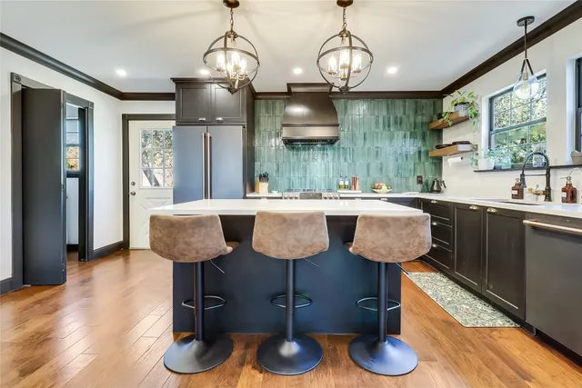 a kitchen with granite countertop a sink cabinets and wooden floor