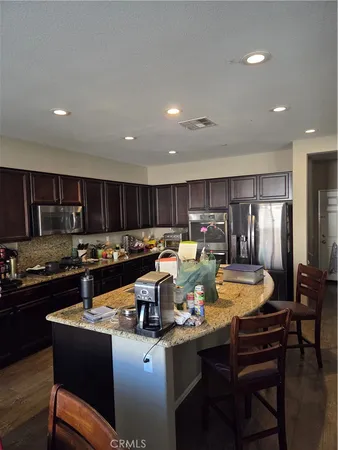 a kitchen with a refrigerator a stove top oven a sink and cabinets