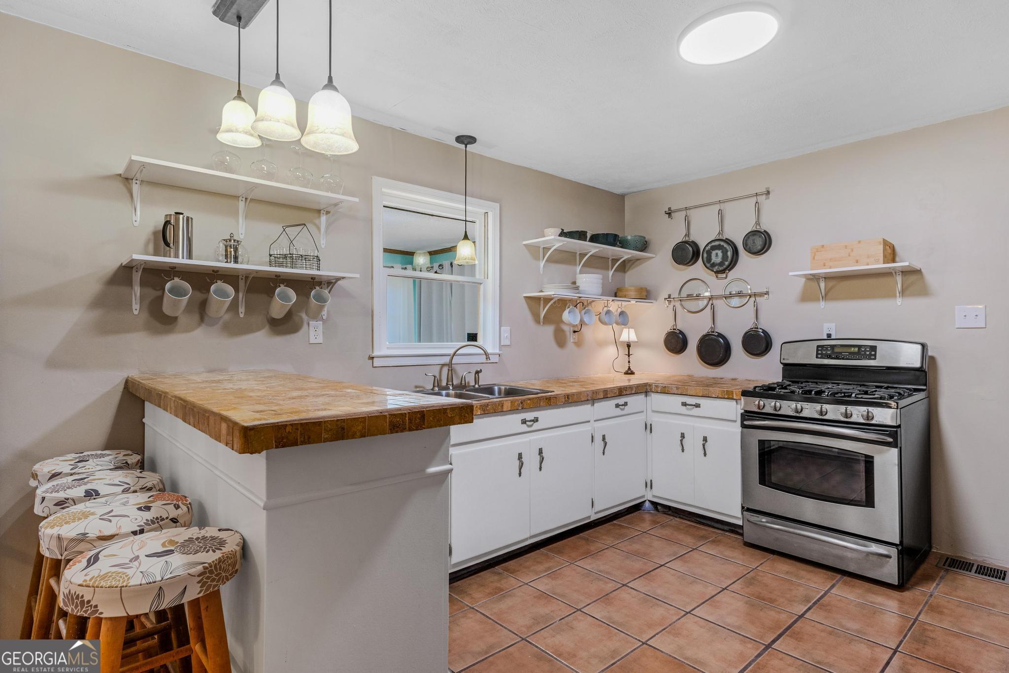 136 Yancey Road Jackson, GA 30233 - Photo 12 of 37 a kitchen with granite countertop a stove a sink and a refrigerator