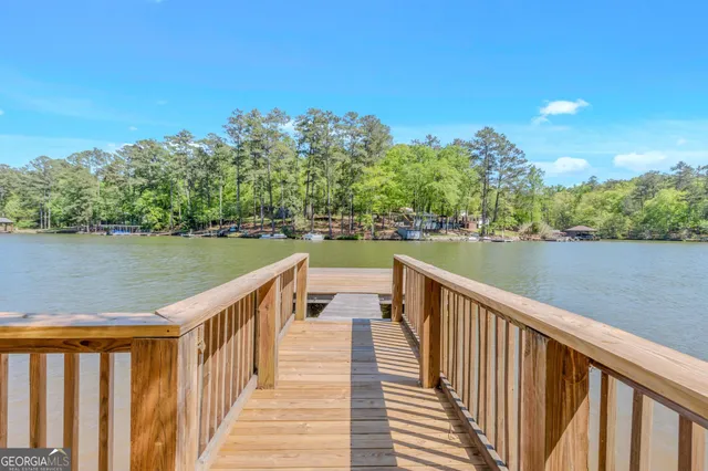 a view of a house with wooden deck and a forest