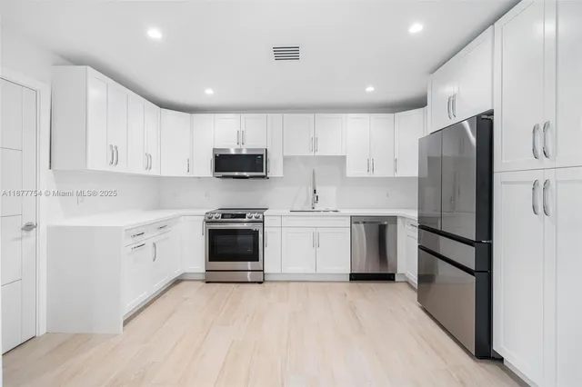 a kitchen with a white cabinets and white stainless steel appliances