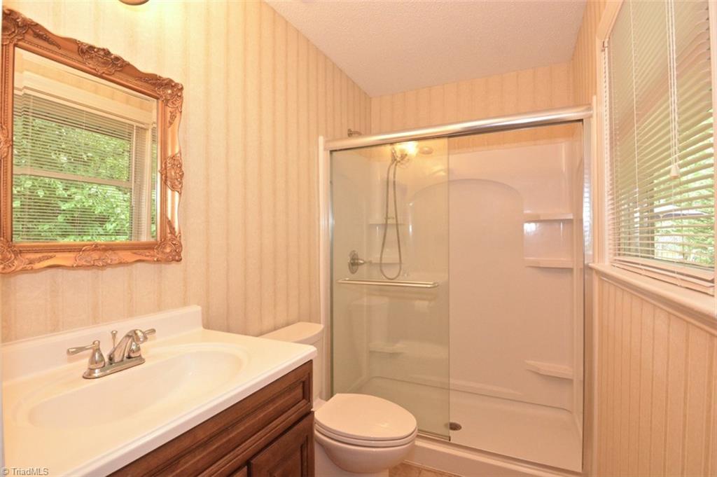 109 Mersey Road Greensboro, NC 27406 - Photo 16 of 28 This lovely bath is great for someone physically challenged. It has a wide door for entry and a walk in shower with a new solid surface extra wide vanity and fixtures. The commode flushes by a hand waving action !
