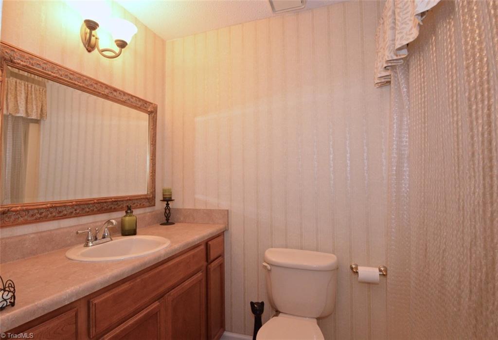 109 Mersey Road Greensboro, NC 27406 - Photo 17 of 28 The hall bath is similar in style to the master bath with a larger vanity and mirror and a tub shower combo. It was also totally remodeled.