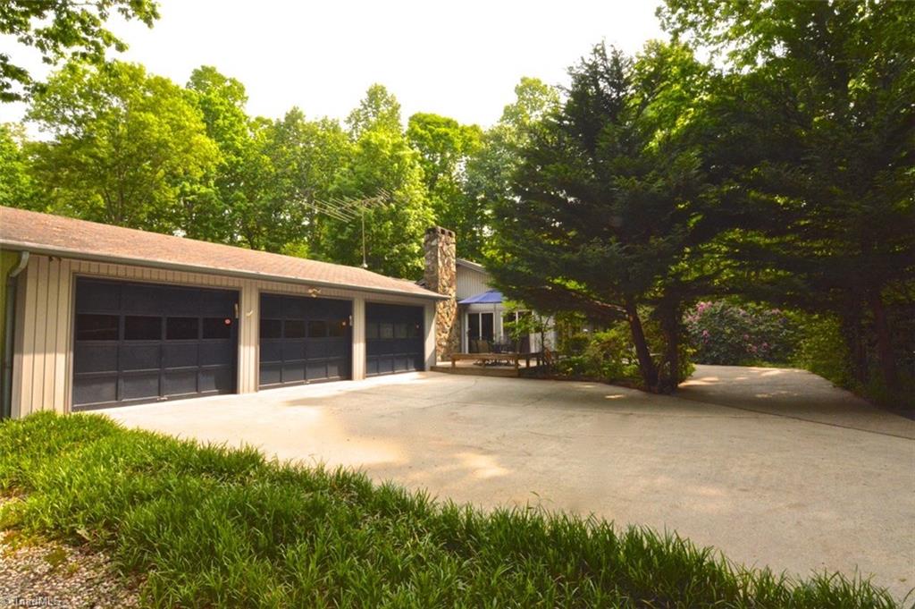 109 Mersey Road Greensboro, NC 27406 - Photo 3 of 28 Super sized garage ...two bays presently hold 3 cars! The third bay is an enclosed insulated office that has exterior and interior entrance off the family room. The pool was built in 2006.