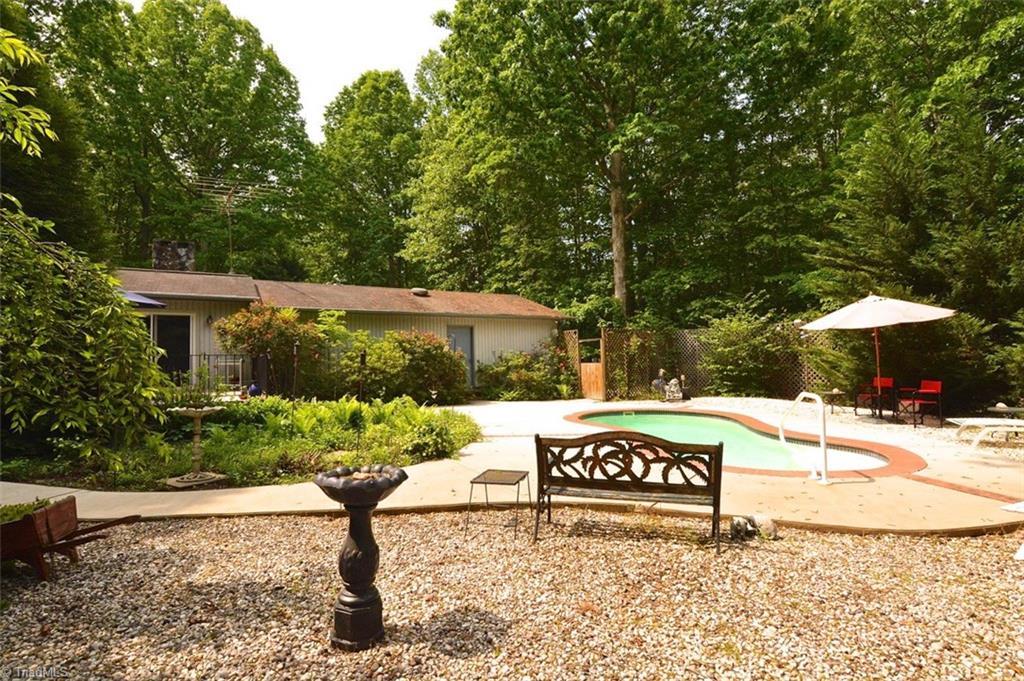 109 Mersey Road Greensboro, NC 27406 - Photo 22 of 28 A spacious patio and walkway allows you to roam freely in the rear yard overlooking the pool. River rock compliments the surroundings.