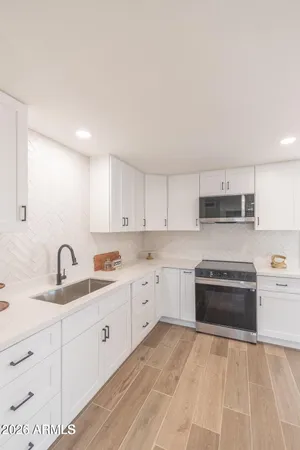 a kitchen with granite countertop a sink stove and cabinets