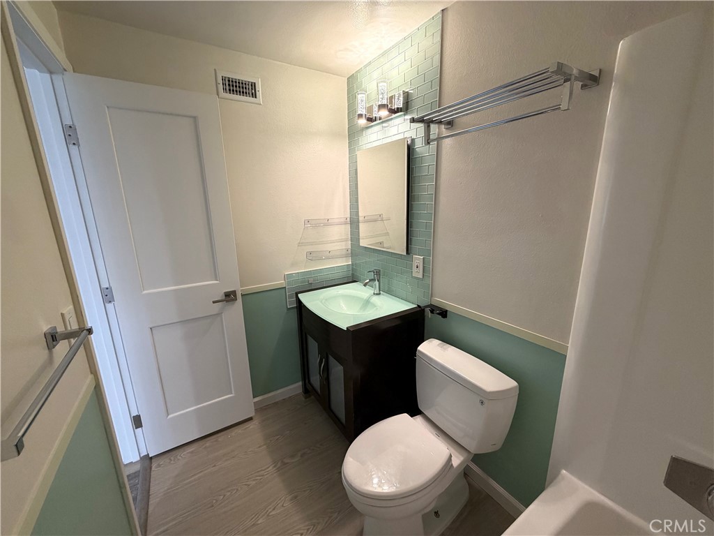 8657 Rumson Drive Santee, CA 92071 - Photo 25 of 65 a bathroom with a toilet a sink and wooden floor