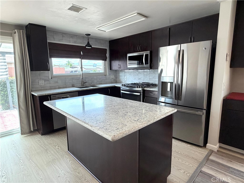 8657 Rumson Drive Santee, CA 92071 - Photo 10 of 65 a kitchen with stainless steel appliances granite countertop a refrigerator a sink a stove a microwave and island