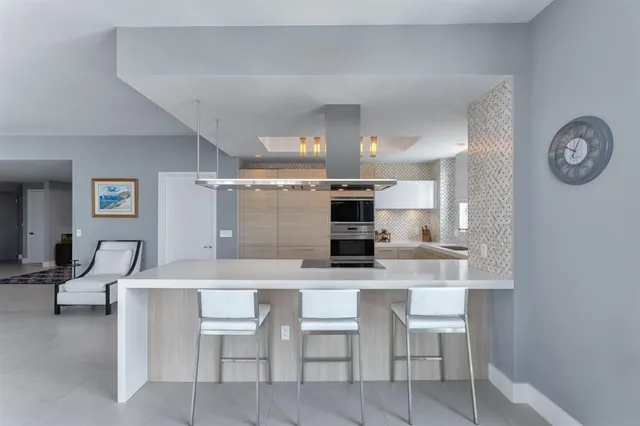 a kitchen with a dining table chairs and a refrigerator