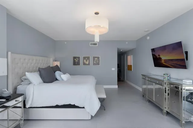 a bedroom with a bed and a flat screen tv