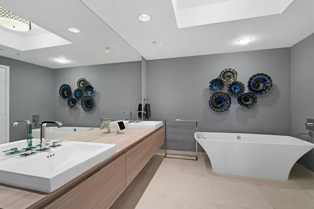 a bathroom with a double vanity sink mirror and bathtub