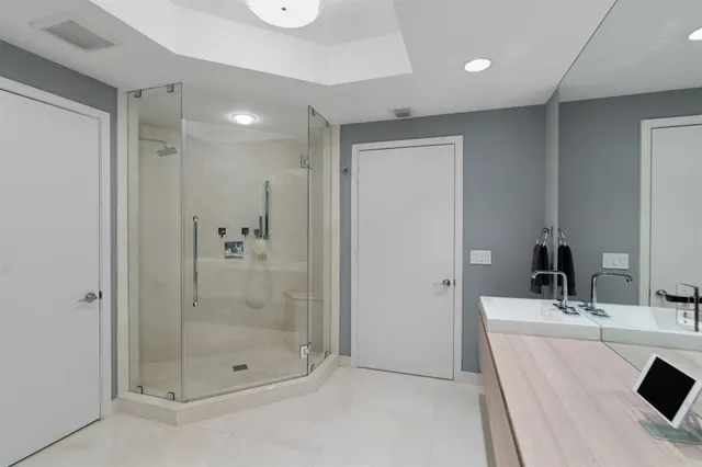 a bathroom with a shower a sink and a mirror