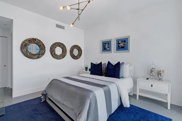 a bedroom with a bed and a chandelier