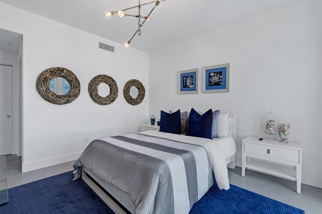 17111 Biscayne Boulevard, Unit 1101 North Miami Beach, FL 33160 - Photo 29 of 43 a bedroom with a bed and a chandelier