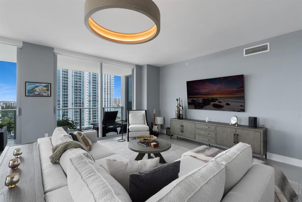 17111 Biscayne Boulevard, Unit 1101 North Miami Beach, FL 33160 - Photo 9 of 43 a living room with furniture a flat screen tv and a large window