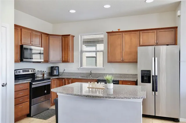 a kitchen with stainless steel appliances granite countertop a refrigerator stove microwave and sink