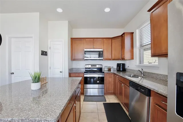 a kitchen with stainless steel appliances granite countertop sink stove and cabinets