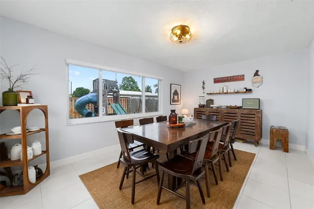 a view of a dining room and livingroom with furniture a rug a chandelier and wooden floor