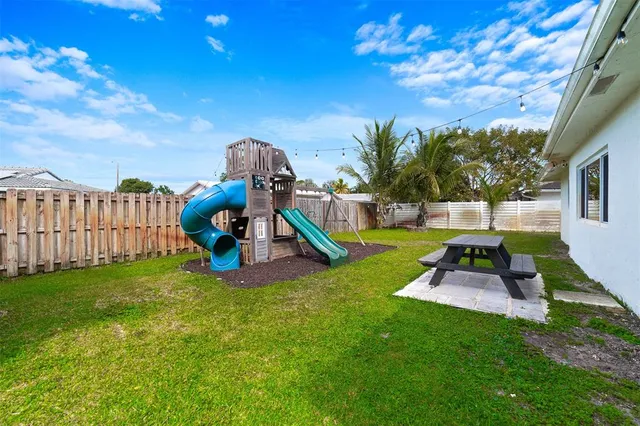 a view of a backyard with a garden and entertaining space