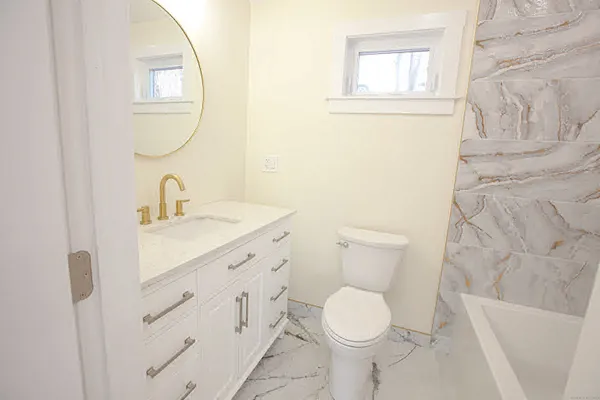 a bathroom with a granite countertop toilet sink and mirror