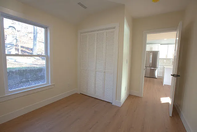 wooden floor in an empty room with a window