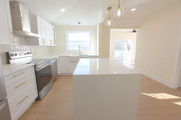 a large kitchen with stainless steel appliances a large window a sink and cabinets