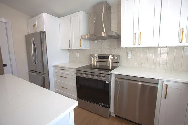 a kitchen with stainless steel appliances white cabinets and a refrigerator