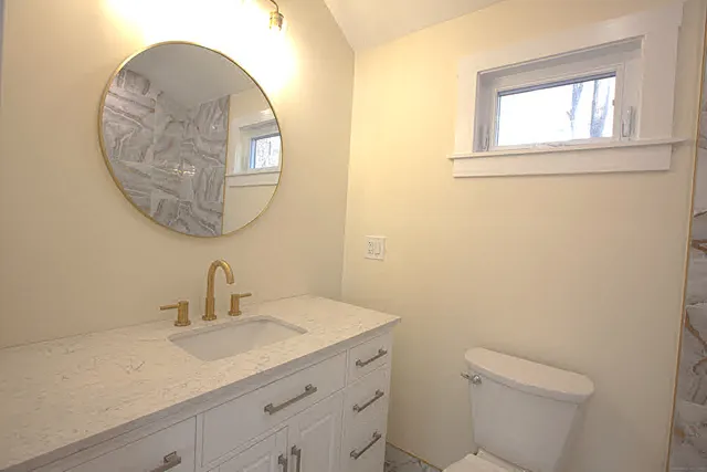 a bathroom with a toilet a sink and mirror