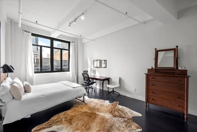 wooden view of walk in closet with clothes and shoes