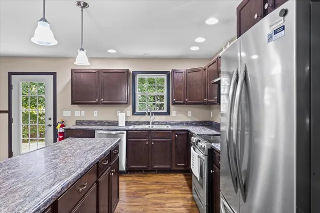 a kitchen with stainless steel appliances granite countertop a sink stove and refrigerator