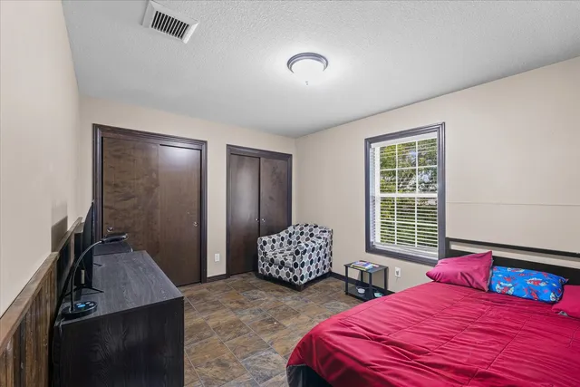 a bedroom with two beds and wooden floor