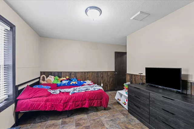 a bedroom with a bed and a flat screen tv