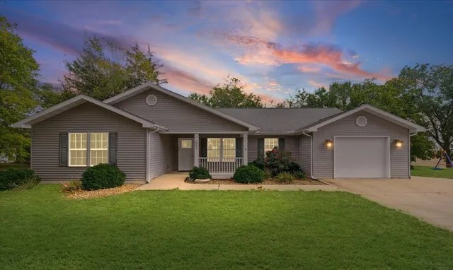 a front view of a house with a yard and garage