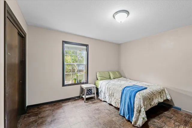a bed sitting in a bedroom next to a window