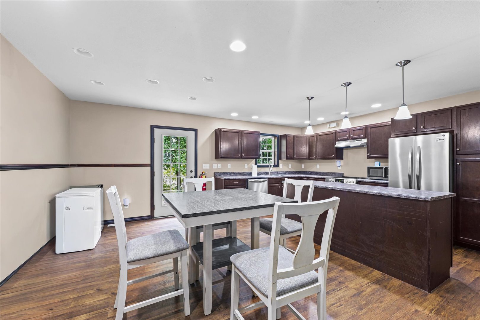 601 Curtis Road Ogden, IL 61859 - Photo 7 of 29 a dining room with stainless steel appliances kitchen island granite countertop a table chairs and a refrigerator