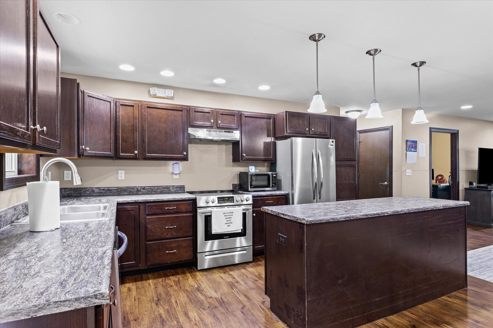 601 Curtis Road Ogden, IL 61859 - Photo 8 of 29 a kitchen with stainless steel appliances granite countertop a stove a sink a refrigerator and a oven with wooden floor