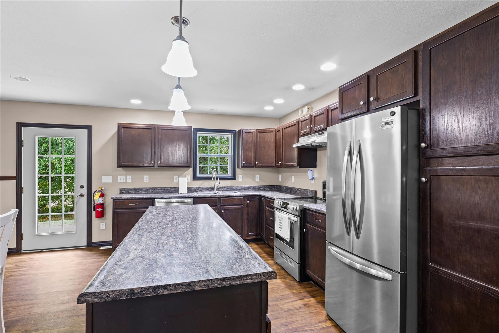 601 Curtis Road Ogden, IL 61859 - Photo 9 of 29 a kitchen with stainless steel appliances granite countertop a refrigerator a sink dishwasher a oven with a dining table and wooden floor
