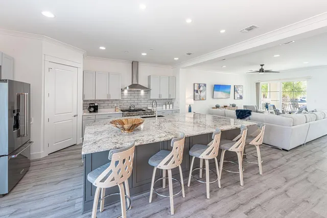 a kitchen with granite countertop a stove a sink and a refrigerator